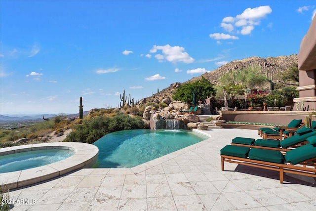 view of pool with an in ground hot tub, a mountain view, pool water feature, and a patio