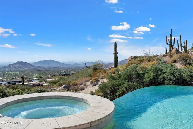 view of pool featuring an in ground hot tub and a mountain view