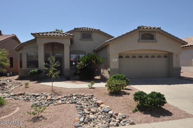 18071 W Douglas Way, Surprise, AZ 85374 - mediterranean / spanish-style house featuring an attached garage, concrete driveway, stucco siding, and a tile roof