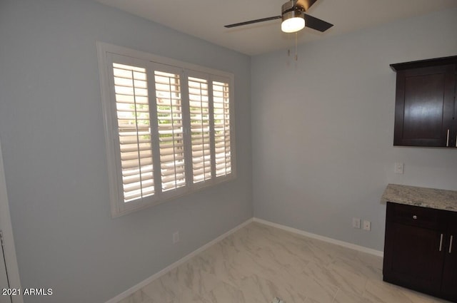 18071 W Douglas Way, Surprise, AZ 85374 - unfurnished dining area featuring a ceiling fan, baseboards, and light marble finish flooring