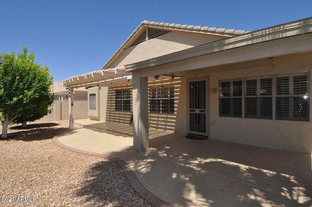 rear view of property featuring a patio and a pergola