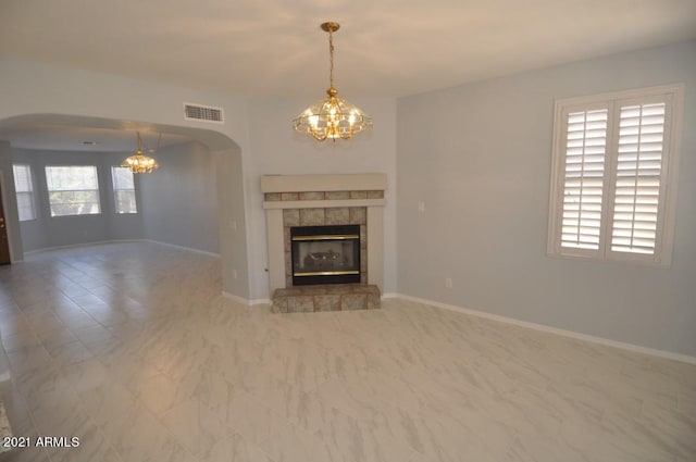 unfurnished living room with a healthy amount of sunlight and a tile fireplace