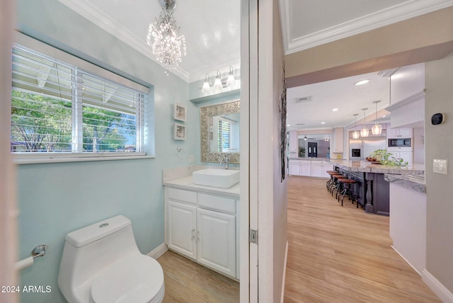 bathroom with toilet, wood-type flooring, crown molding, and vanity