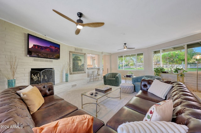 living room with a brick fireplace and ceiling fan