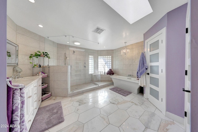 bathroom featuring vanity, independent shower and bath, tile walls, and tile patterned flooring