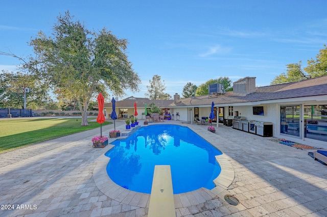 view of pool featuring a patio, a yard, and a diving board