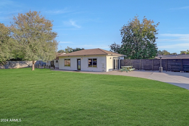 rear view of property featuring a patio and a yard