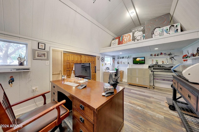 office space featuring high vaulted ceiling and light hardwood / wood-style flooring