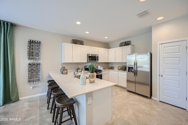 kitchen featuring sink, a breakfast bar area, white cabinets, kitchen peninsula, and stainless steel appliances