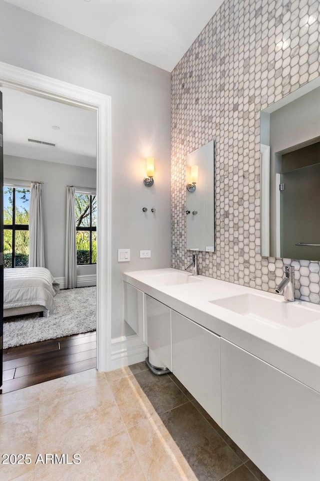26099 N 88th Way, Scottsdale, AZ 85255 - bathroom featuring an accent wall, tasteful backsplash, a sink, double vanity, and ensuite bathroom