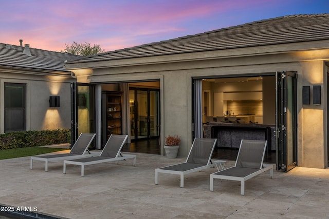 26099 N 88th Way, Scottsdale, AZ 85255 - back of property at dusk with stucco siding, a tile roof, and a patio area
