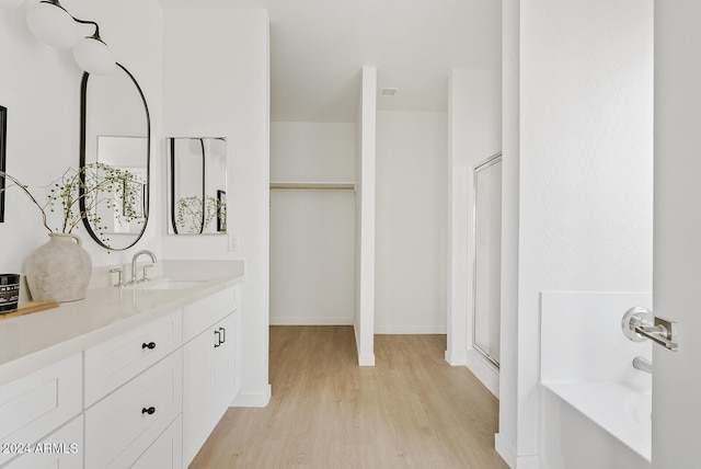 bathroom with hardwood / wood-style floors, vanity, and separate shower and tub