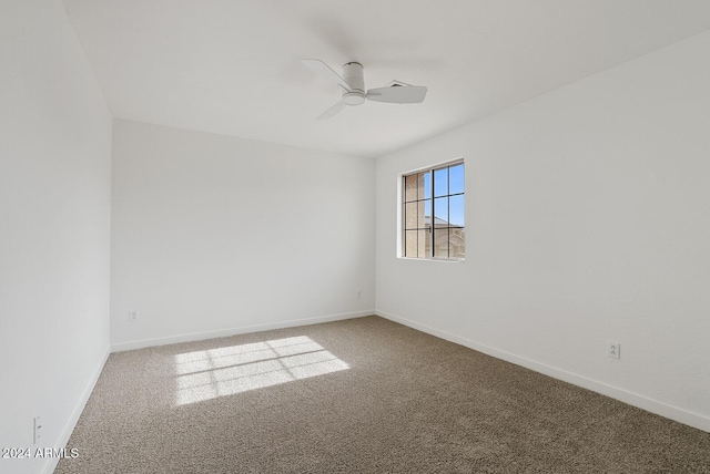 spare room with ceiling fan and carpet