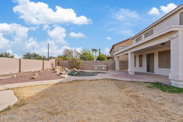 view of yard with a fenced in pool and a patio