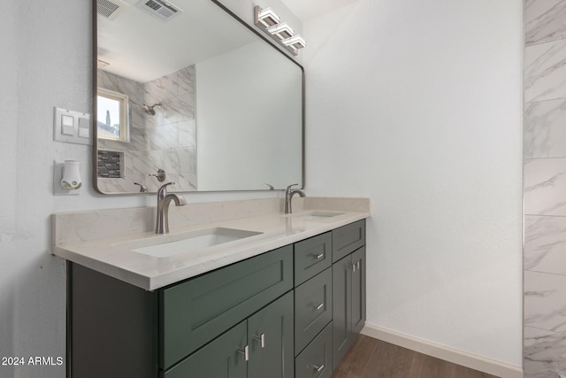 bathroom with vanity, a tile shower, and hardwood / wood-style flooring