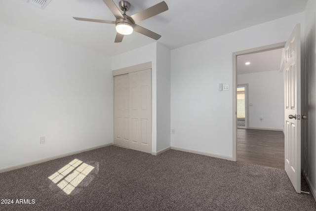 unfurnished bedroom with a closet, ceiling fan, and dark hardwood / wood-style flooring