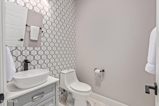 bathroom featuring toilet, backsplash, and vanity