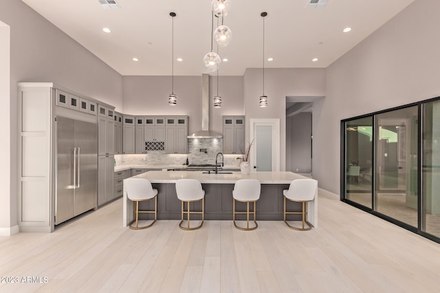 kitchen with a high ceiling, gray cabinetry, and decorative light fixtures