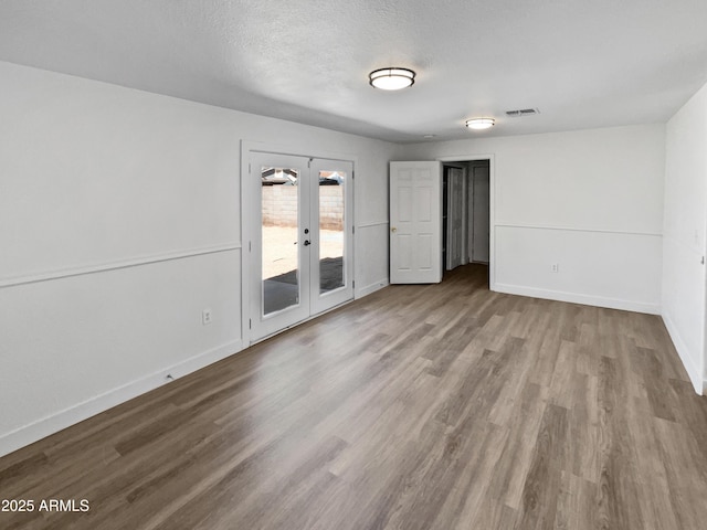 5308 N 77th Dr, Glendale, AZ 85303 - empty room featuring baseboards, french doors, wood finished floors, and a textured ceiling