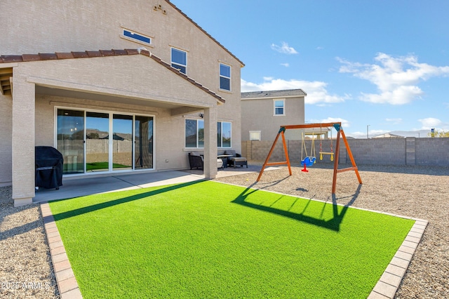 back of property with a lawn, a patio area, and a playground