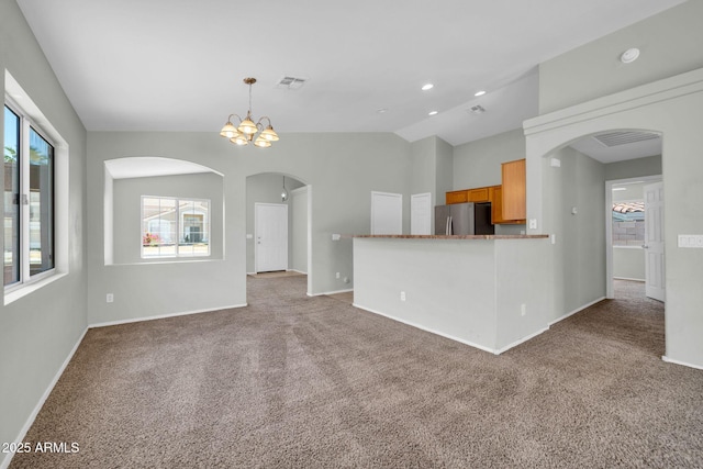 11154 W Ashley Chantil Dr, Surprise, AZ 85378 - unfurnished living room with arched walkways, light carpet, baseboards, lofted ceiling, and a chandelier