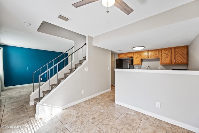 kitchen with ceiling fan and black fridge