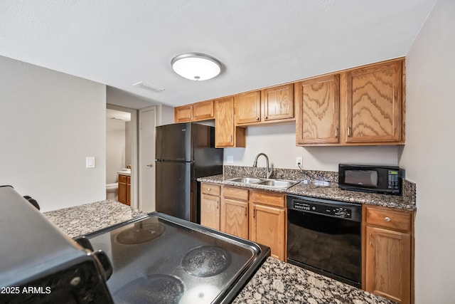 kitchen featuring sink, black appliances, and dark stone counters