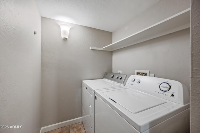 laundry area with a textured ceiling, washer and dryer, and light tile patterned floors