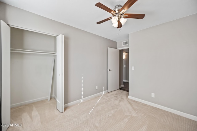 unfurnished bedroom with light carpet, ceiling fan, and a closet