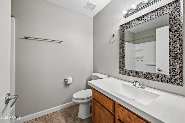 bathroom with vanity, tile patterned flooring, toilet, and walk in shower