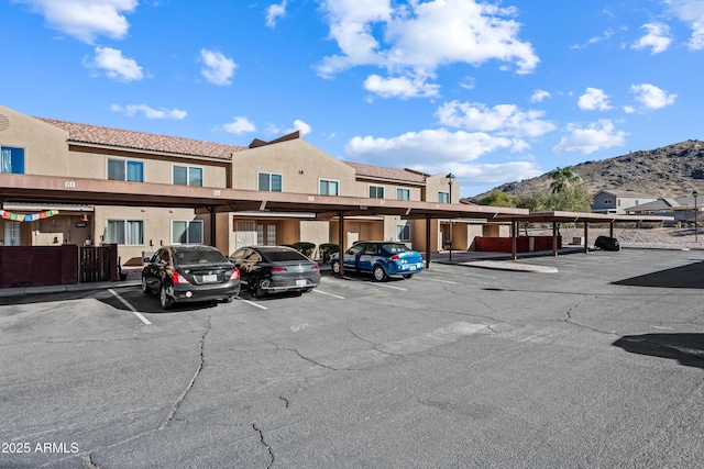 view of parking / parking lot with a carport and a mountain view