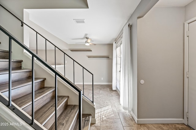 stairway featuring ceiling fan and tile patterned floors