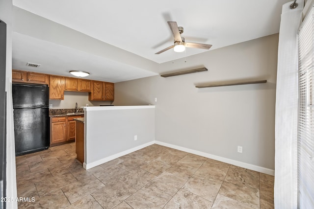 kitchen with black refrigerator, ceiling fan, and sink