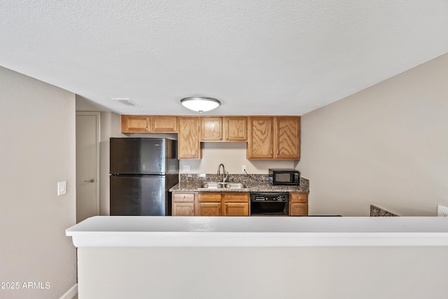 kitchen with sink, a textured ceiling, and black appliances