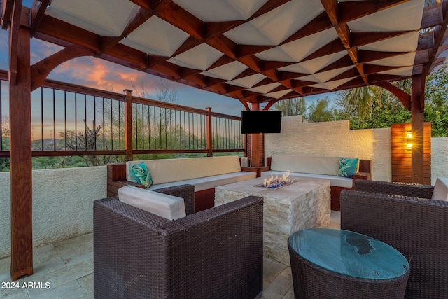 patio terrace at dusk with an outdoor living space with a fire pit