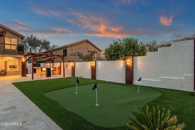 yard at dusk featuring a patio and an outdoor bar