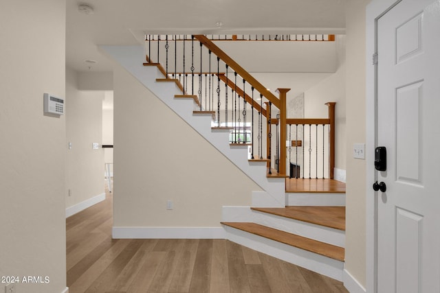 stairs featuring hardwood / wood-style floors