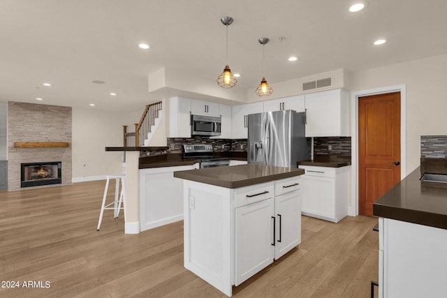 kitchen featuring light hardwood / wood-style flooring, white cabinetry, appliances with stainless steel finishes, and a kitchen island