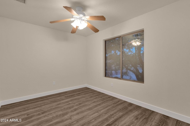 unfurnished room with ceiling fan and dark wood-type flooring