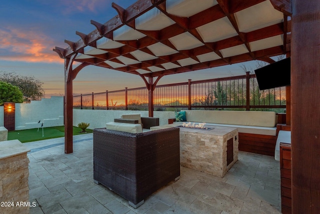 patio terrace at dusk featuring a pergola and an outdoor fire pit