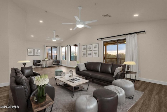 living room with ceiling fan, lofted ceiling, and dark wood-type flooring