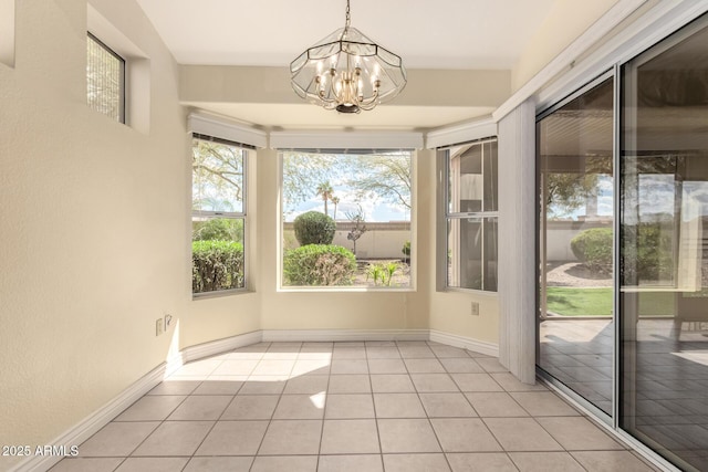 interior space with light tile patterned floors, a notable chandelier, and baseboards