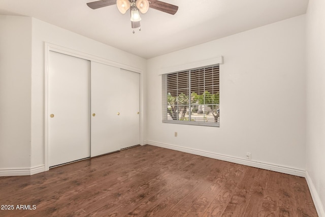 unfurnished bedroom featuring a closet, ceiling fan, baseboards, and wood finished floors