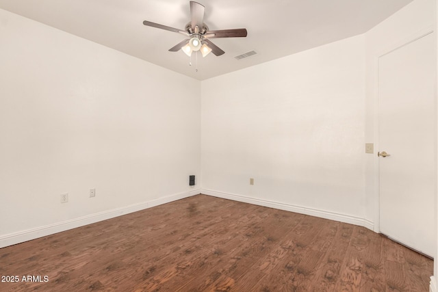 spare room with baseboards, wood finished floors, visible vents, and ceiling fan