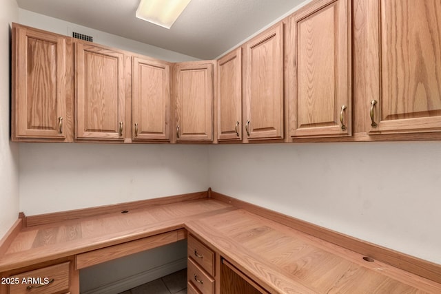 unfurnished office featuring visible vents and built in desk