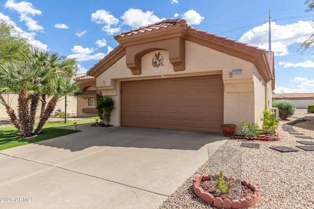 mediterranean / spanish house featuring stucco siding, a garage, concrete driveway, and a tile roof