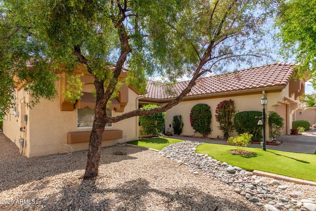 view of property exterior with a tiled roof, a yard, and stucco siding