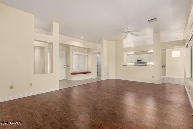 unfurnished living room featuring visible vents, baseboards, ceiling fan, and wood-type flooring