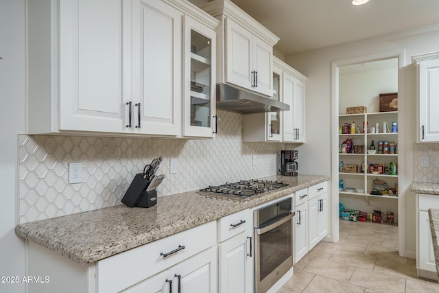 kitchen featuring appliances with stainless steel finishes, white cabinets, and light stone counters