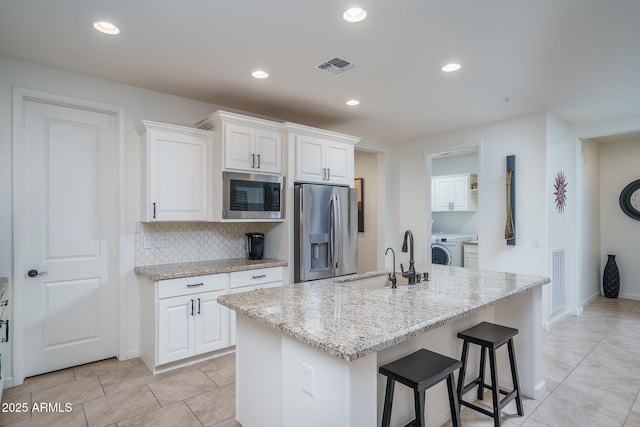 kitchen featuring sink, stainless steel appliances, an island with sink, and white cabinets